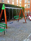 REF 196. Columpio y tobogán. Parque en Huesca:
Tobogán pequeño, columpio doble de madera con asientos planos y bancos verdes