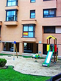 REF 23. Conjunto parque infantil. Urbanización en Fuencarral (Madrid):
Muelle balancín, muelle coche, doble columpio y torre tobogán sobre arena y delimitado por medios troncos.