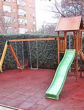 REF 30. Parque infantil. Comunidad de vecinos en Torrejon de Ardoz (Madrid):
Columpio doble con torre sobre tobogan y suelo de caucho